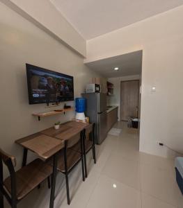 a living room with a table and a refrigerator at Cozy 1BR Prime World District, Near Airport, Gaisano Grand Mall, Mactan Doctor's Hospital in Agus