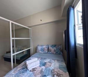 a small bedroom with a bed and a window at Cozy 1BR Prime World District, Near Airport, Gaisano Grand Mall, Mactan Doctor's Hospital in Agus +19 photos