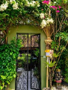 a green house with a black door with flowers at The Lodge Canggu in Tumbak Bayuh