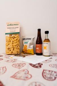 a table with a bottle of beer and a basket of pasta at Dolomitihouse NOGHERA in Fiera di Primiero