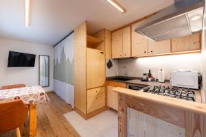 a kitchen with wooden cabinets and a stove top oven at Dolomitihouse NOGHERA in Fiera di Primiero