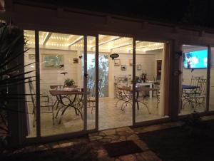 a room with glass doors and tables and chairs at Villa don peppe in Selva di Fasano