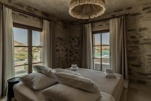 a bedroom with a bed with pillows and a chandelier at Eunoia Suites in Krotiri