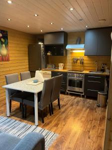 a kitchen with a table and chairs in a kitchen at Hortensia in Mariehamn