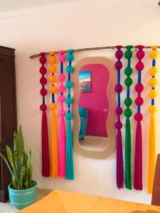 a wall with a mirror and colorful tassels at Magic Colombia in El Porvenir