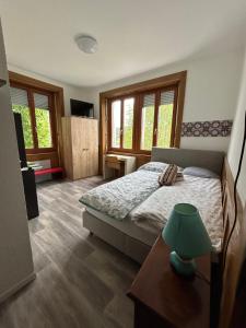 a bedroom with a bed and a table with a lamp at Studio in Tramelan