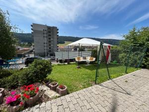 a garden with a tent and a bench and flowers at Studio in Tramelan