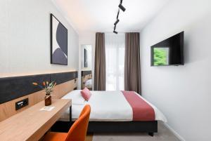 a hotel room with a bed and a desk at Tailormade Hotel AL GIARDINETTO Biasca in Biasca