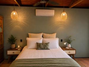 a bedroom with a large bed with white pillows at Gunnadoo Holiday Hut with Ocean Views and Jacuzzi in Miallo