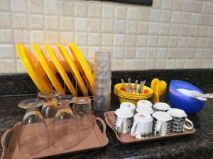 a counter with two trays with utensils and cups and utensils at Sandunes ReTreat Villa in Pondicherry