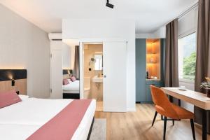 a hotel room with a bed and a desk at Tailormade Hotel AL GIARDINETTO Biasca in Biasca +51 photos