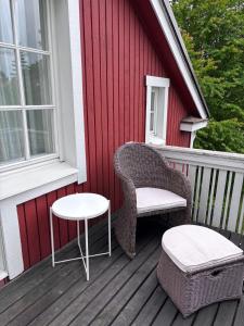 a wicker chair and a table on a porch at Huoneisto Petsamossa in Tampere +3 photos