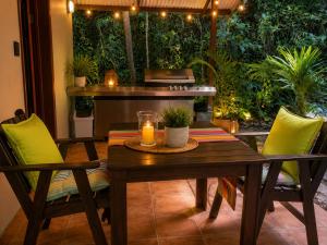 a patio with a table and chairs with a candle at Gunnadoo Holiday Hut with Ocean Views and Jacuzzi in Miallo