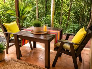a wooden table and chairs on a patio at Gunnadoo Holiday Hut with Ocean Views and Jacuzzi in Miallo +27 photos
