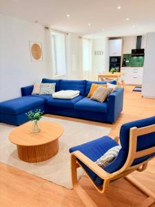 a blue couch and chairs in a living room at Le Salon des Voyageurs - Appartement Climatisé avec Terrasse et Parking Gratuit à Proximité in Dole