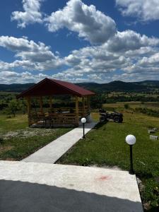 a gazebo with a car parked in a field at Panorama Residence Ivan in Pljevlja