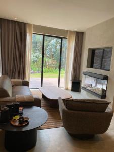 a living room filled with furniture and a large window at Ubucuti Gorilla Lodge in Kinigi