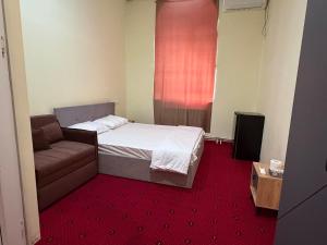 ein kleines Schlafzimmer mit einem Bett und einer Couch in der Unterkunft Ruma Hotel in Yerevan + 26 Fotos