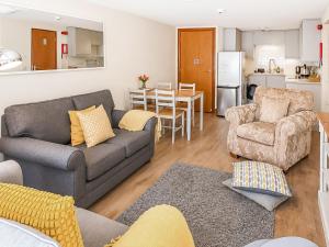 a living room with a couch and a chair and a table at Howgills Apartment 7 - Ukc9722 in Sedbergh