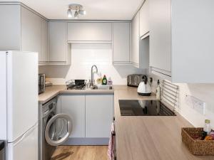 a white kitchen with a sink and a dishwasher at Howgills Apartment 7 - Ukc9722 in Sedbergh