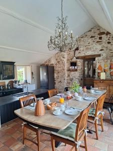 a dining room with a table and a kitchen at La Boire Bavard in Blaison