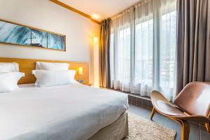 a hotel room with a large bed and a window at Hotel Le Morgane in Chamonix-Mont-Blanc