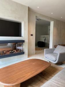 a living room with a fireplace with a tv and a coffee table at Ubucuti Gorilla Lodge in Kinigi +3 photos