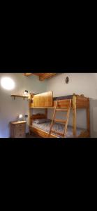 a bedroom with two bunk beds and a desk at Baita PUPILLE in Osteria Alpina