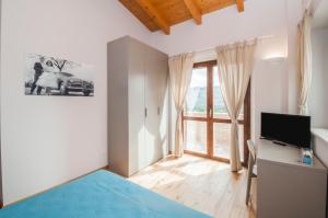 a bedroom with a bed and a large window at Moresco Agriturismo in Moresco