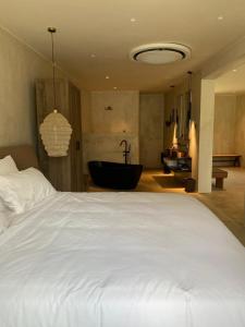 a bedroom with a large bed and a bath tub at Ubucuti Gorilla Lodge in Kinigi