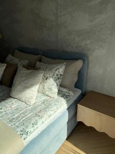 a bed with a blue headboard and pillows on it at Apartament Lake Mood Iława in Iława