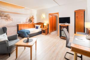 a hotel room with a bed and a desk at Hotel Novum in Hinte