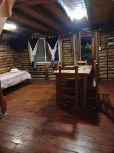 a room with a bed and a table in a cabin at Complejo del Canton Valais in Baradero +1 photo