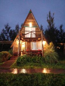 a wooden house with lights on the front of it at Complejo del Canton Valais in Baradero