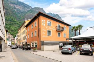 a building on the side of a street with cars parked at Tailormade Hotel AL GIARDINETTO Biasca in Biasca