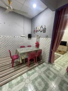 a dining room with a table and red chairs at KAK JA HomeStay in Paka