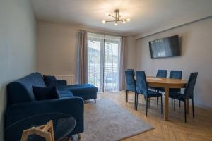 a living room with a blue couch and a table and chairs at Pod Reglami in Krościenko