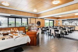 a dining room with tables and chairs in a restaurant at Tailormade Hotel AL GIARDINETTO Biasca in Biasca
