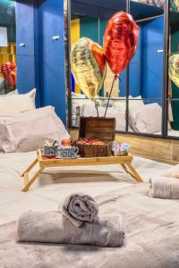 a room with a bed with balloons and a table at JADE Hammam & Jacuzzi in Brie-Comte-Robert