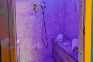 a purple bathroom with a shower with a shower head at JADE Hammam & Jacuzzi in Brie-Comte-Robert