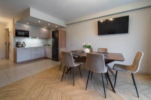 a dining room with a table and chairs and a kitchen at Pod Reglami in Krościenko