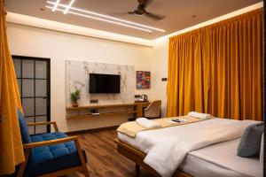 a hotel room with two beds and a television at Barefoot bliss by iLiF Hotels in Revadanda