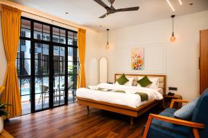 a bedroom with a bed and a large window at Barefoot bliss by iLiF Hotels in Revadanda +86 photos