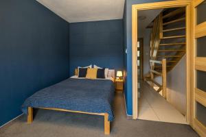 a blue bedroom with a bed and a staircase at Pod Reglami in Krościenko