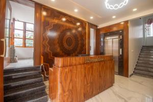 a lobby with stairs and a large wooden counter at Hotel Town Palace in Shimoga