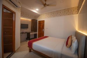 a bedroom with a bed and a desk in it at Hotel Town Palace in Shimoga +3 photos