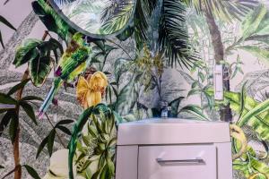 a bathroom with a mural of plants and a sink at JADE Hammam & Jacuzzi in Brie-Comte-Robert