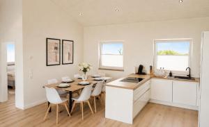 a kitchen and dining room with a table and chairs at Ferienhaus Elbdeichblick 2 in Haselau