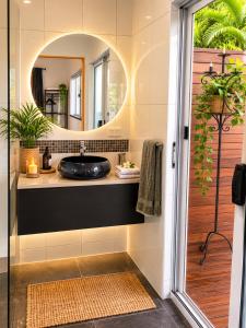 a bathroom with a sink and a mirror at Sky: rainforest and ocean views with jacuzzi in Miallo +27 photos