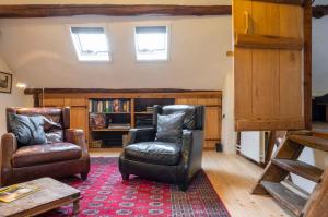 a living room with two chairs and a book shelf at Op de Klever in Schimmert